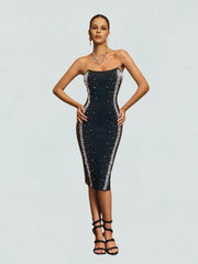 Woman wearing a black strapless dress with sequin details on a light gray background