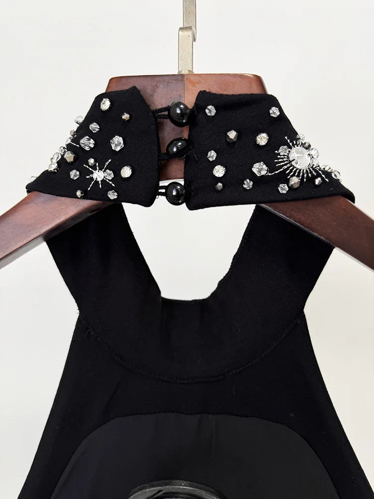 Black dress with embellished collar on a mannequin against a white background
