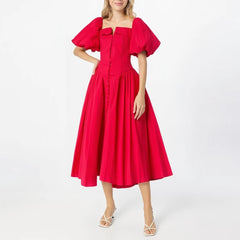 Red dress with puff sleeves worn by a model on a white background