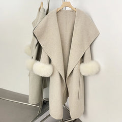 Beige wool blend coat with white fur trim, open front.