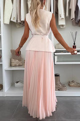 Woman wearing a white top and pink pleated skirt in a clothing store.