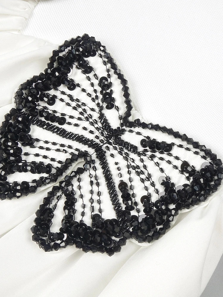 Black beaded butterfly accessory on a white background