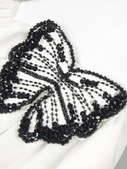Black beaded butterfly accessory on a white background