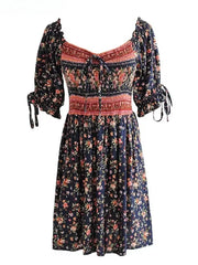 Close-up view of the dark floral print mini dress fabric and smocked waist