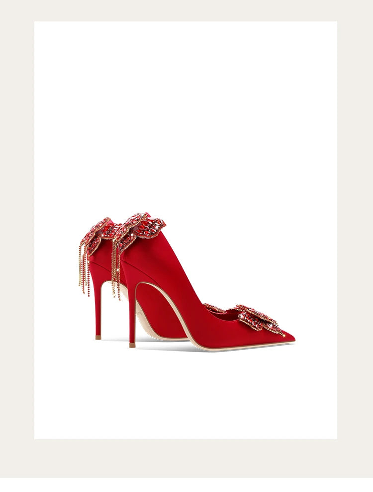Red high-heeled shoe with decorative elements on a white background