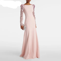 Pink evening gown with floral embellishments on sleeves, held by a model against a white background, featuring the brand 'TwoTwinStyle'.