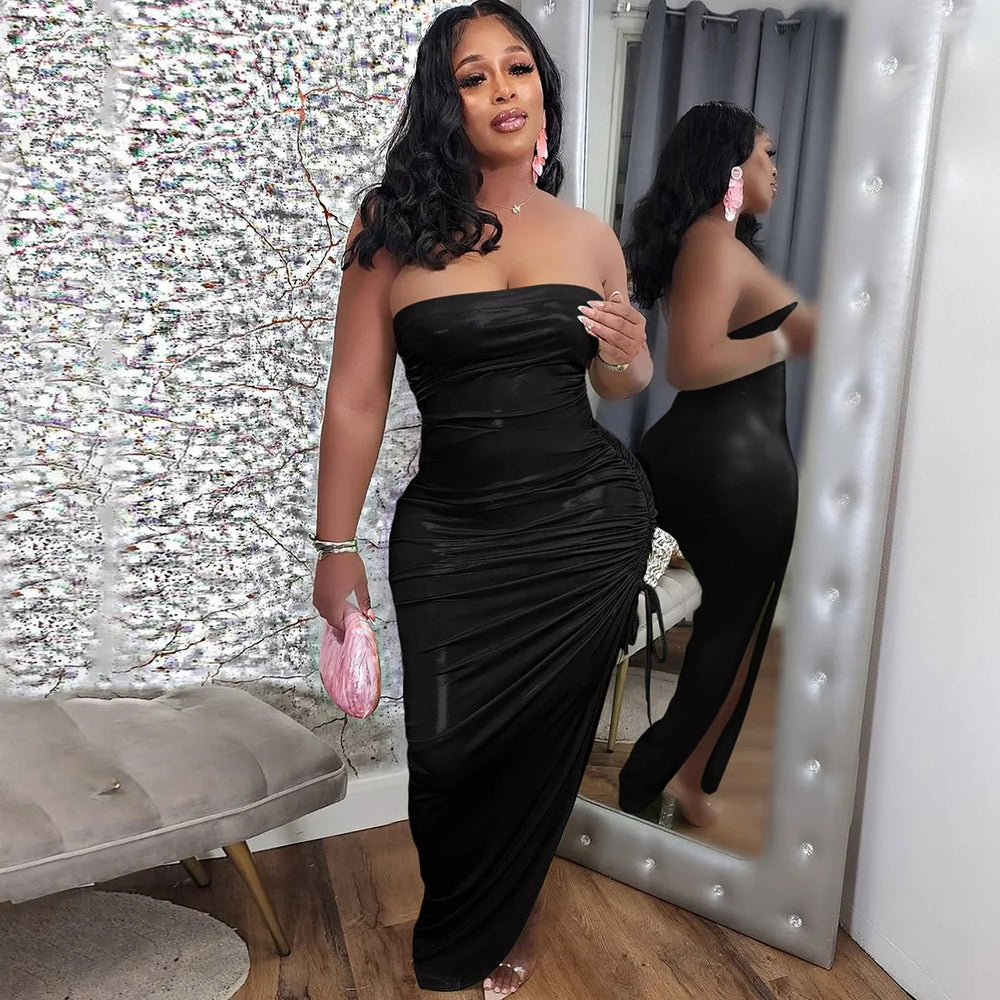 Woman in a black ice-silk fabric texture on a co-ord party set, standing in front of a mirror with a decorative wall behind her.