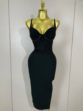 Black dress with bead detailing on a mannequin against a white background