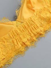 Yellow lace fabric with fringes on a gray background