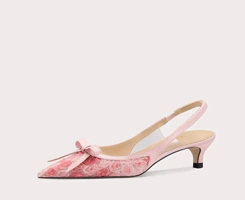 Pink high-heeled shoe with floral design on a white background