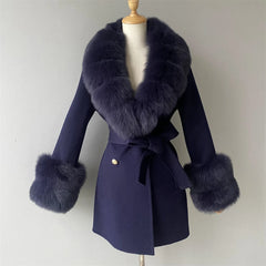 Navy blue coat with fur accents on a mannequin against a plain background