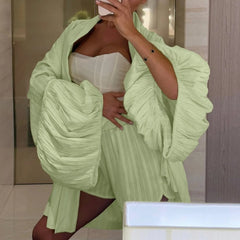 Person wearing a light green outfit with a white top, standing in front of a mirror.