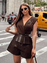 Woman in a brown dress with leather accents on a city street.