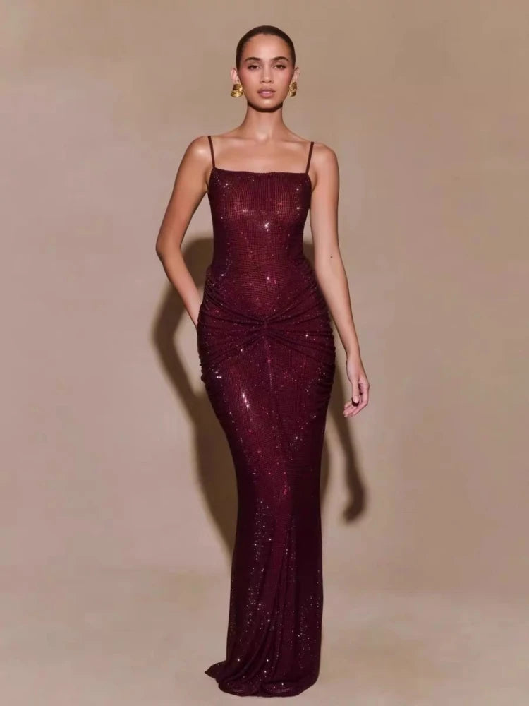 Woman wearing a burgundy evening gown with a plain background