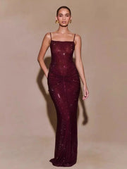 Woman wearing a burgundy evening gown with a plain background