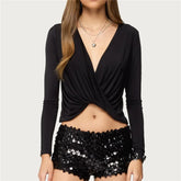 Black long-sleeve top and black sequin shorts on a plain background