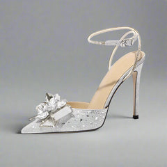 Silver high-heeled shoe with decorative flower on a white background