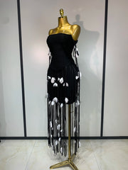 Side view of black strapless bodycon mini dress with tassel trim