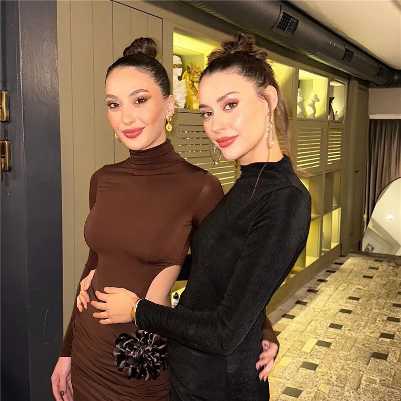 Two women posing together in a stylish indoor setting.