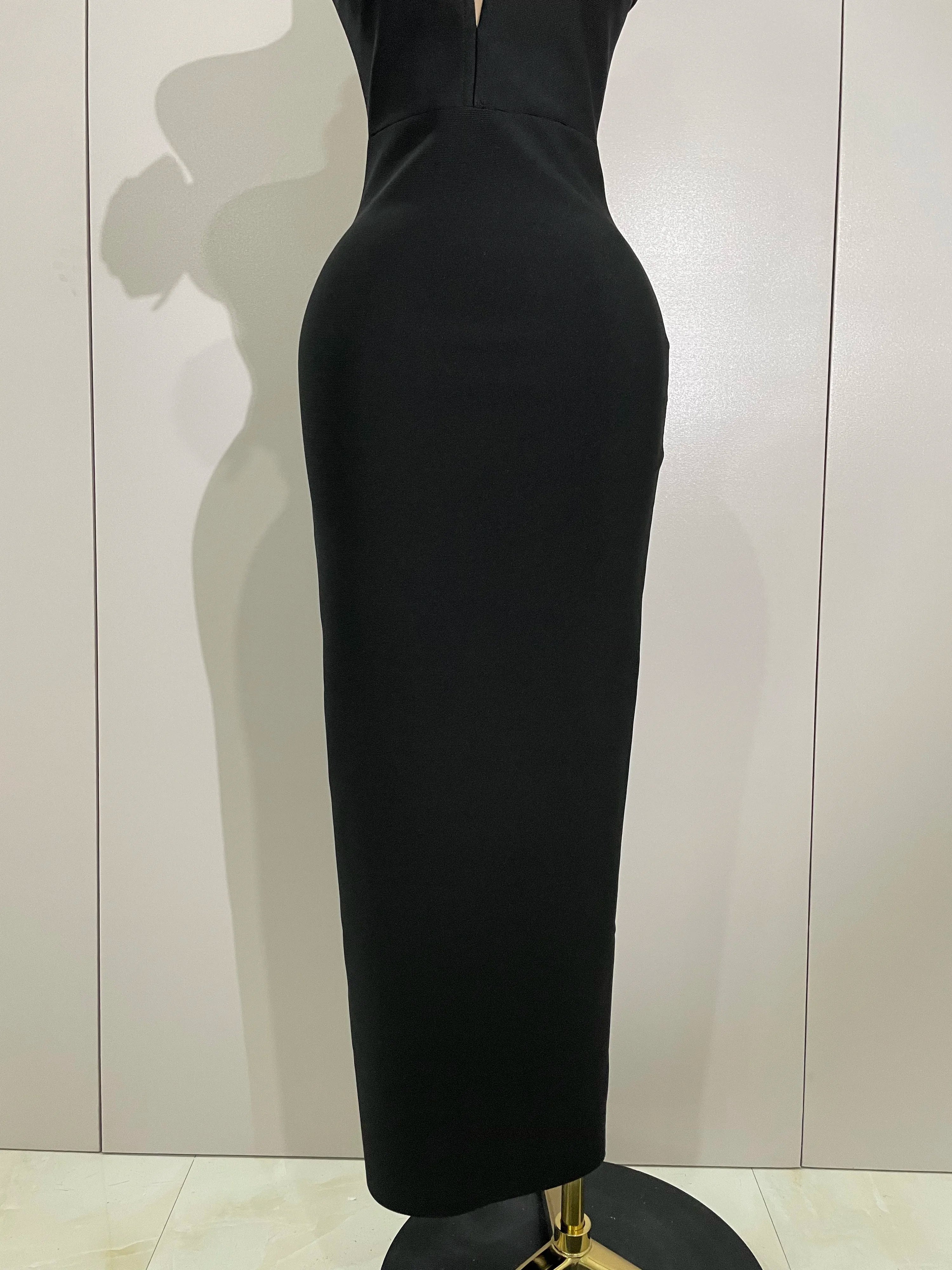 Black dress on a mannequin against a plain background