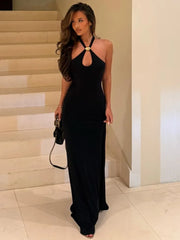 Person wearing a black halter neck maxi dress with gold ring