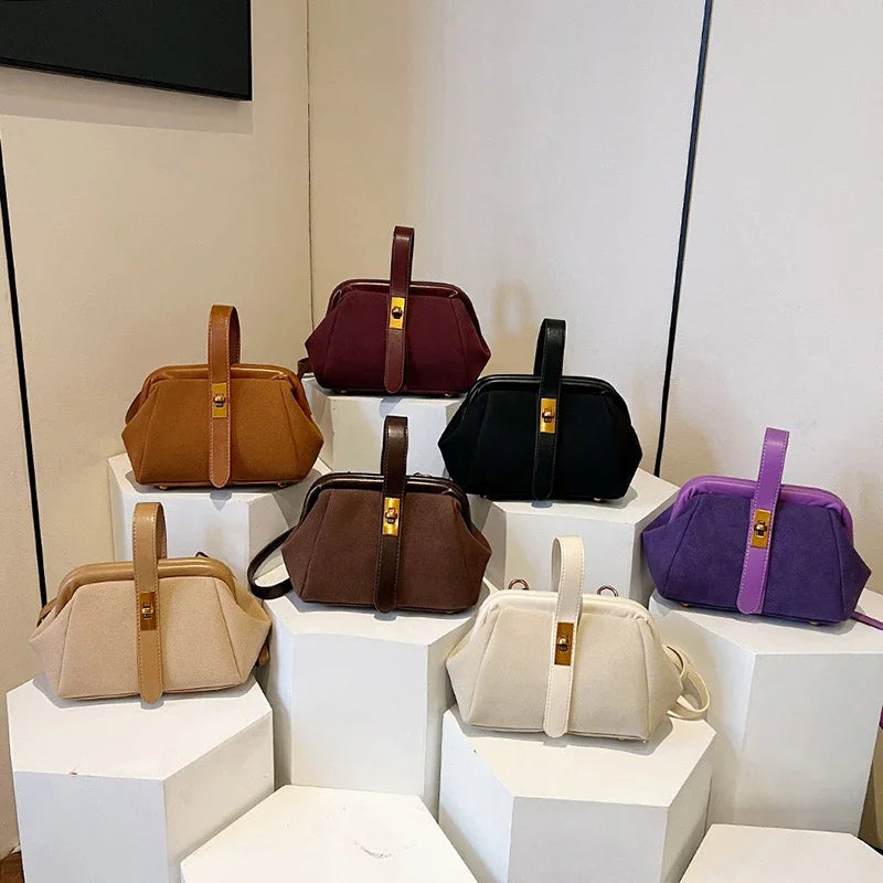 Collection of handbags in various colors displayed on white cubes.