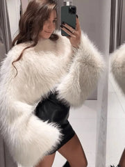 Person wearing a white fluffy coat taking a mirror selfie.