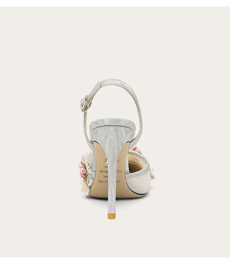 White high-heeled shoe with floral details on a light gray background