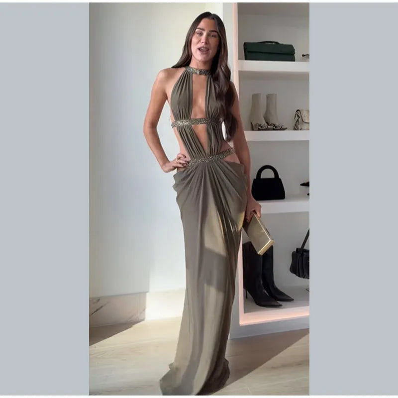 Woman in a long, elegant dress standing in a room with shelves displaying bags.