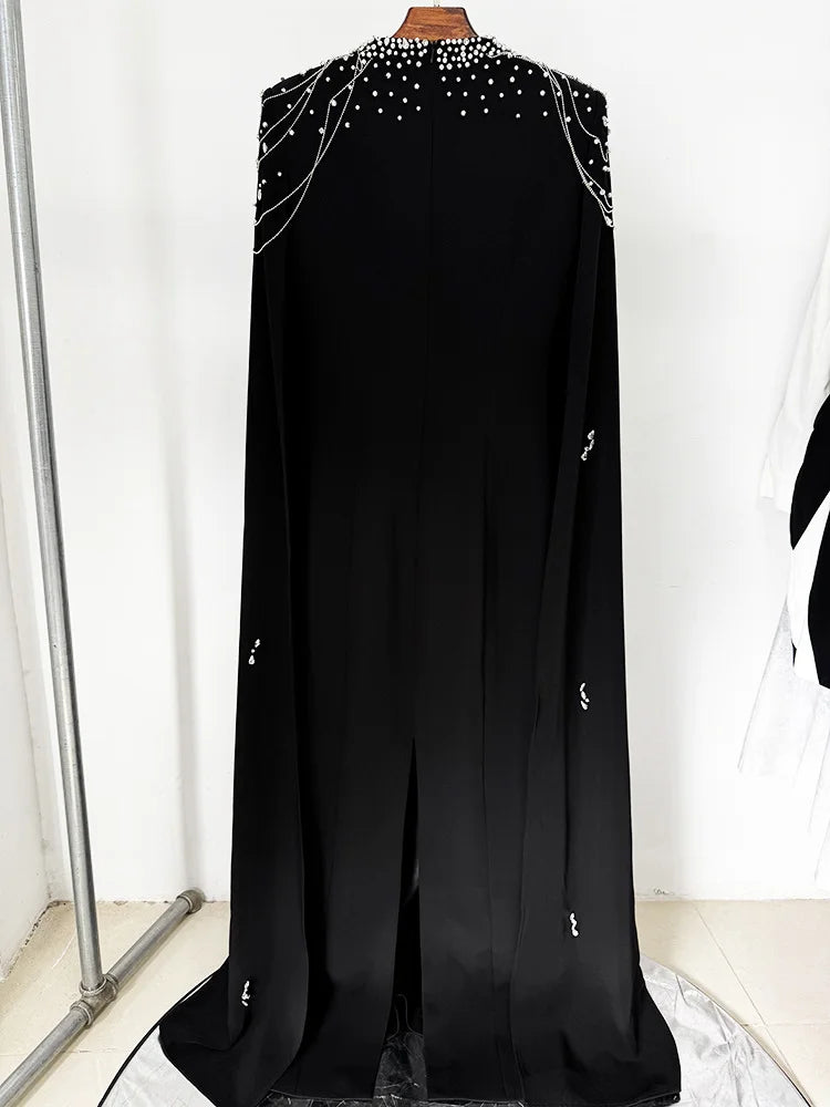 Black cape dress with beaded shoulders displayed