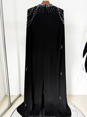 Black cape dress with beaded shoulders displayed