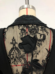 Black lace garment with floral design on a mannequin against a white background