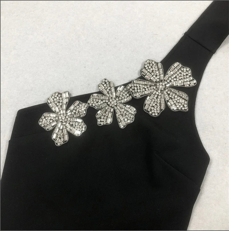Black garment with silver floral embellishments on a white background