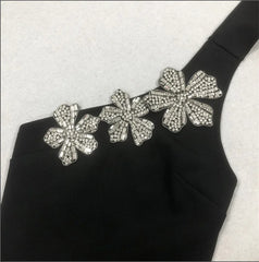 Black garment with silver floral embellishments on a white background