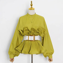 Green blouse with ruffled details and a white belt on a mannequin against a white background