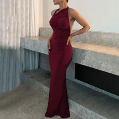 Woman in a burgundy evening gown standing on a staircase.