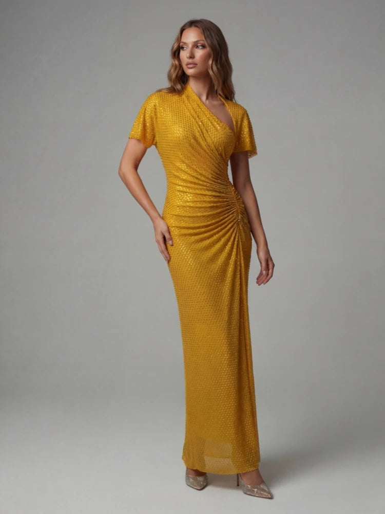 Woman wearing a mustard yellow dress against a gray background