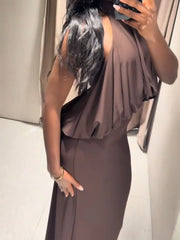 Person wearing a brown dress taking a mirror selfie.