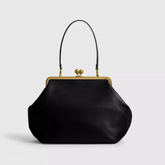 Black handbag with gold clasp on a light gray background