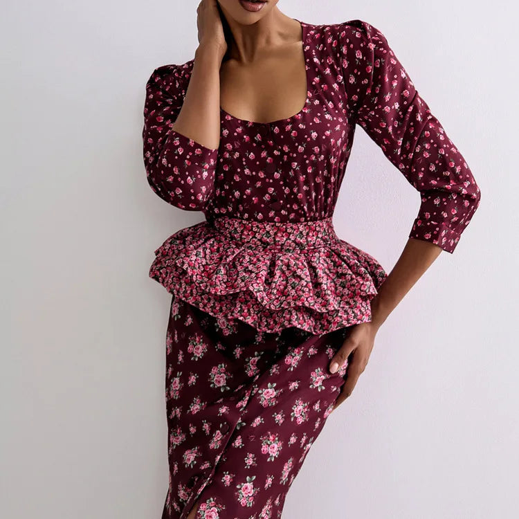 Woman wearing a maroon floral dress with a peplum waist on a white background