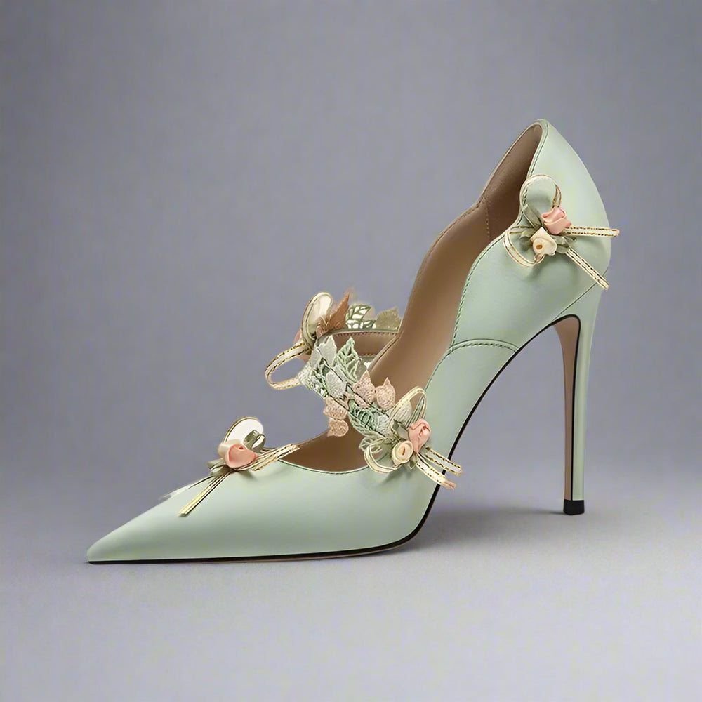 Mint green high-heeled shoe with floral decorations on a white background