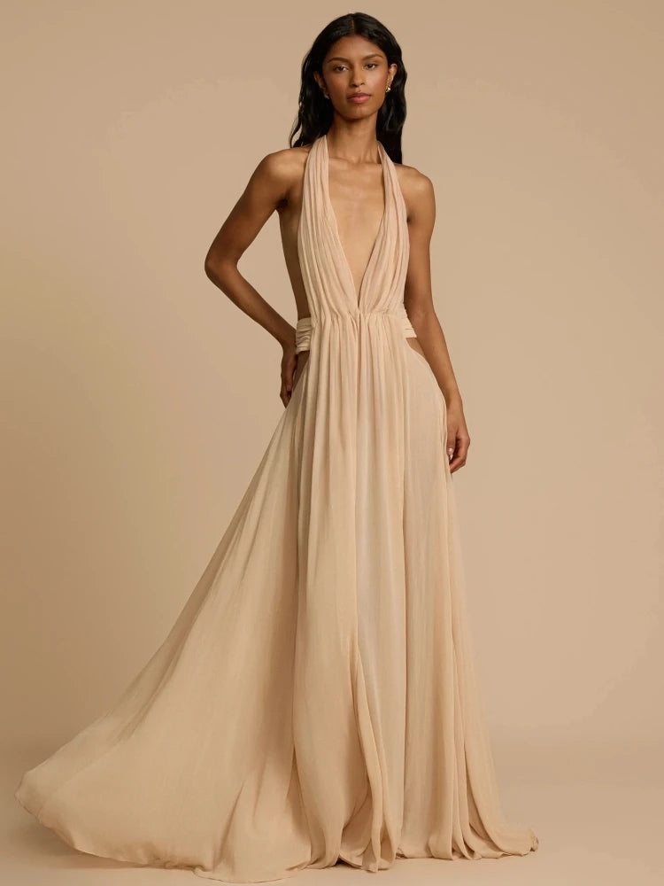 Woman wearing a beige halter neck gown against a beige background