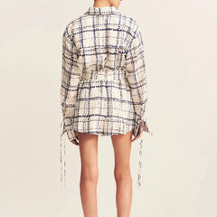 Plaid shirt dress worn by a person on a beige background