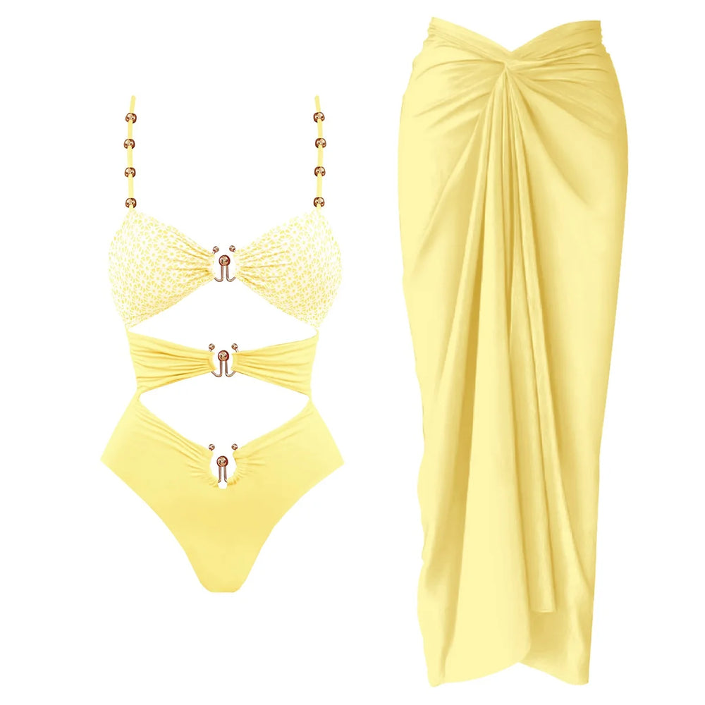 Yellow cutout one-piece swimsuit with embellished straps and matching draped cover-up skirt.