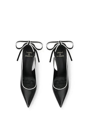 Black high-heeled shoes with bow details on a white background