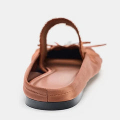 Back view of a reddish brown mule flat showing the heel and sole.
