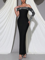 Black off-shoulder evening gown with sequin details on a white draped background