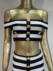 Mannequin wearing a black and white striped top with gold buttons on a gray background