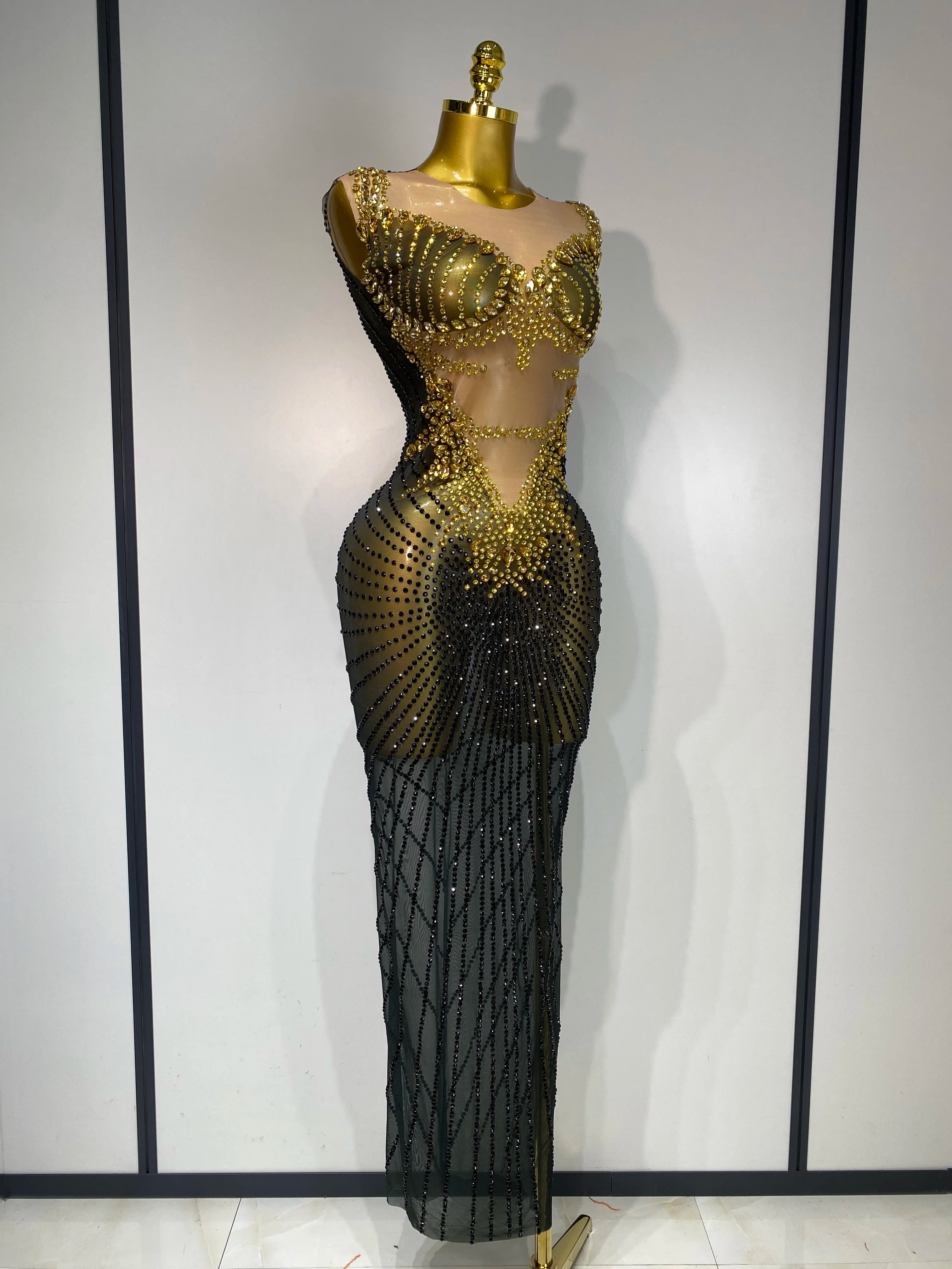 Black and gold evening gown on a mannequin against a white background