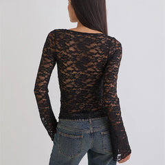 Person wearing a black lace long-sleeve top over a denim jacket on a light gray background